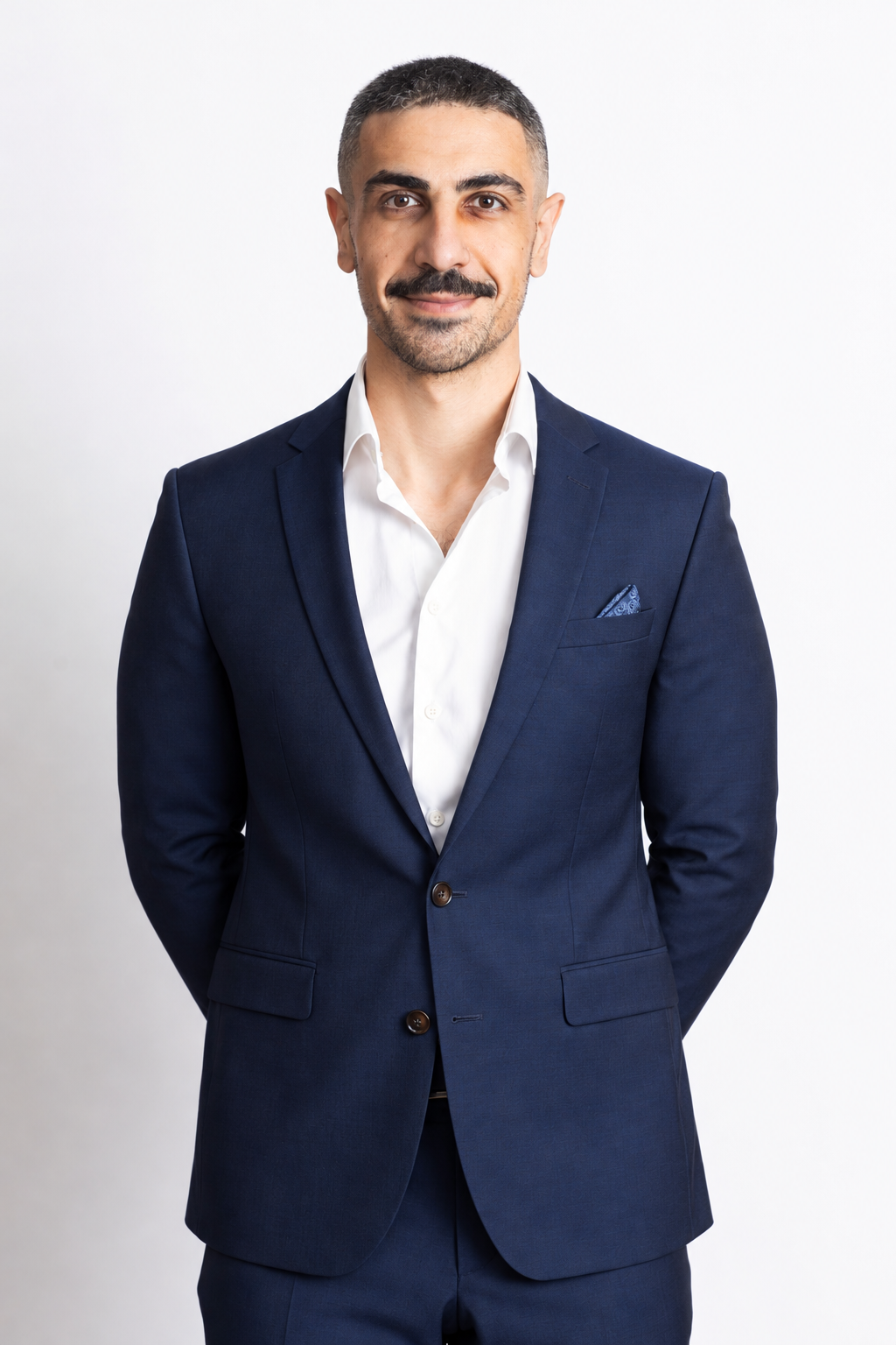 Mohammed S. Hadi smiling, wearing a navy suit and a white shirt
